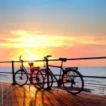 Twee fietsen op het strand. Zonsondergang. Silhouet .